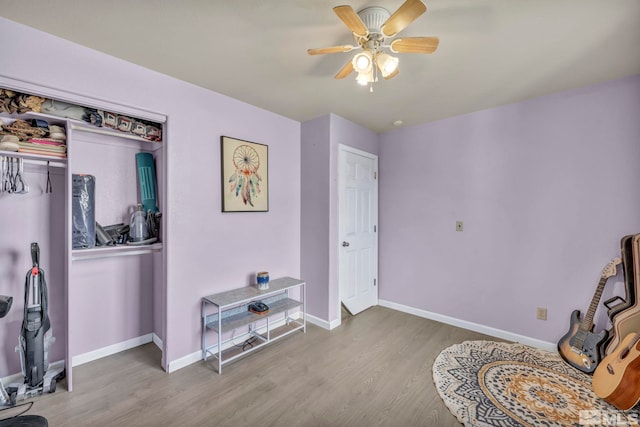 living area with hardwood / wood-style flooring and ceiling fan