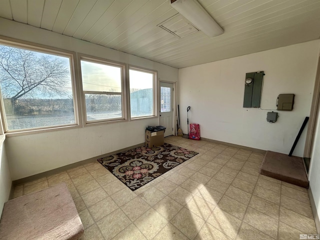 sunroom with electric panel and a water view