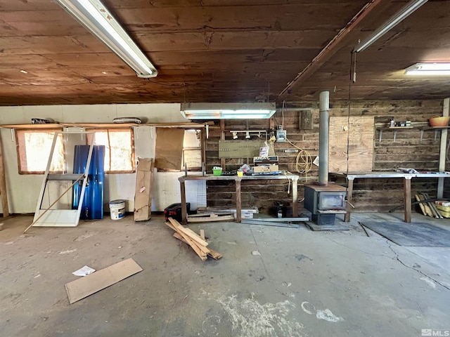 miscellaneous room with a wood stove and a workshop area