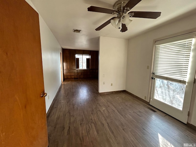 spare room with ceiling fan, plenty of natural light, and dark hardwood / wood-style floors