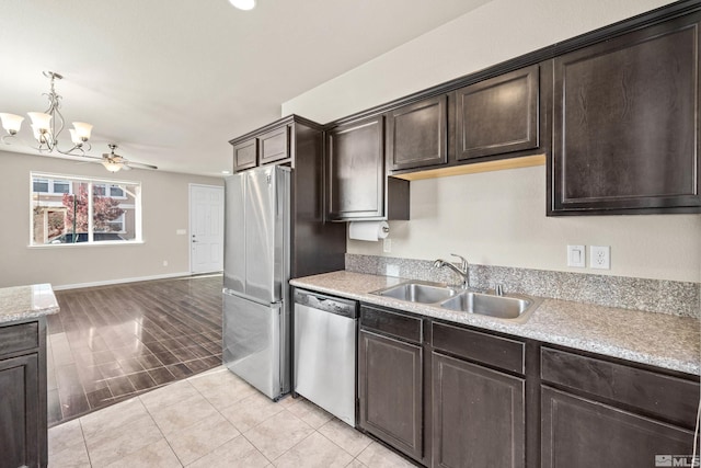 kitchen featuring sink, light hardwood / wood-style floors, dark brown cabinets, ceiling fan with notable chandelier, and appliances with stainless steel finishes