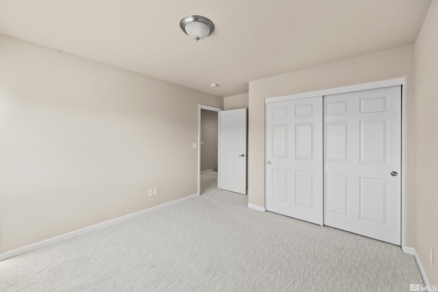 unfurnished bedroom featuring light colored carpet and a closet