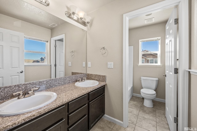 bathroom with tile patterned flooring, vanity, toilet, and a healthy amount of sunlight