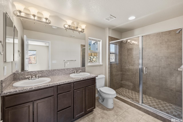 bathroom with tile patterned floors, a textured ceiling, an enclosed shower, toilet, and vanity