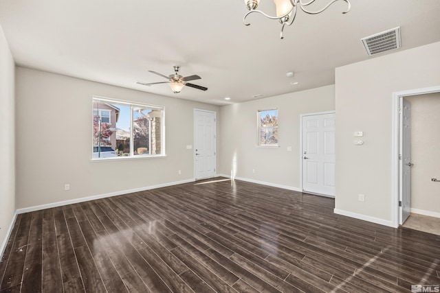 unfurnished living room with ceiling fan with notable chandelier and dark hardwood / wood-style flooring