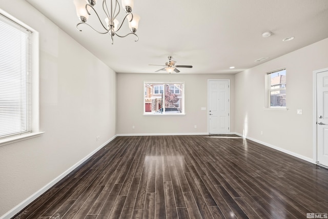 interior space featuring ceiling fan with notable chandelier and dark hardwood / wood-style floors