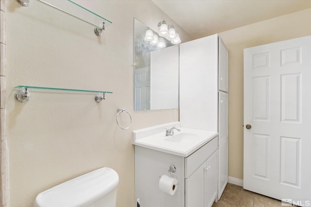 bathroom featuring tile patterned flooring, vanity, and toilet