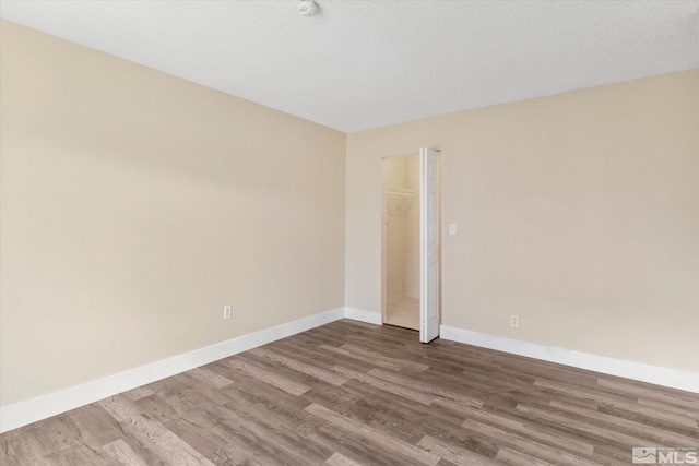 spare room featuring a textured ceiling and hardwood / wood-style flooring