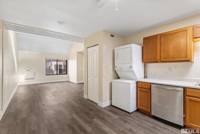 kitchen featuring stacked washer and dryer, vaulted ceiling, stainless steel dishwasher, ceiling fan, and dark hardwood / wood-style flooring