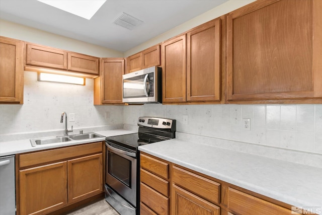 kitchen featuring light wood-type flooring, stainless steel appliances, and sink