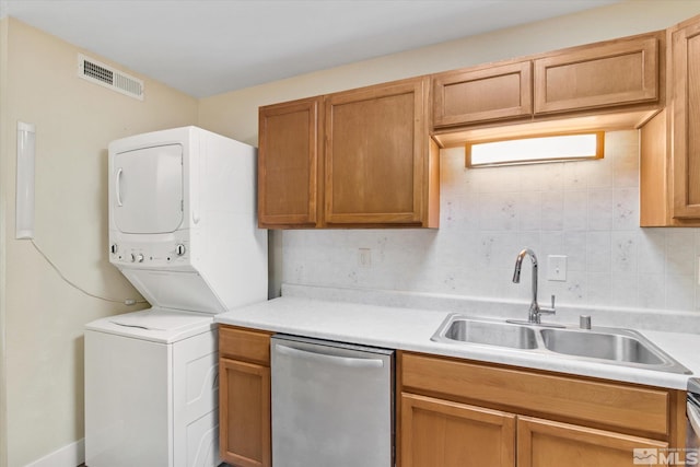 kitchen with dishwasher, decorative backsplash, stacked washer / dryer, and sink