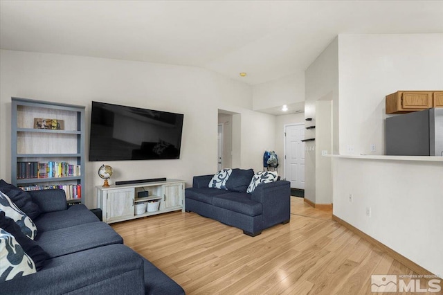 living room featuring light hardwood / wood-style floors and vaulted ceiling