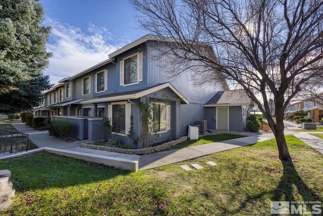 view of front of property featuring a front yard and cooling unit