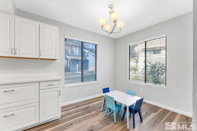 dining area featuring light hardwood / wood-style floors and a chandelier