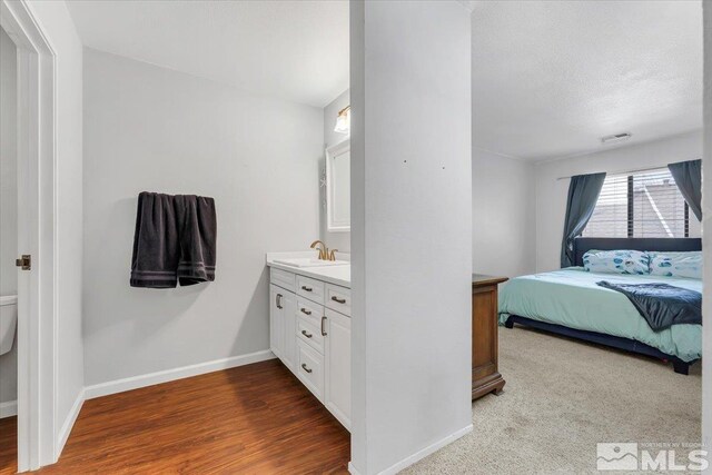 bedroom featuring sink, a textured ceiling, and hardwood / wood-style flooring