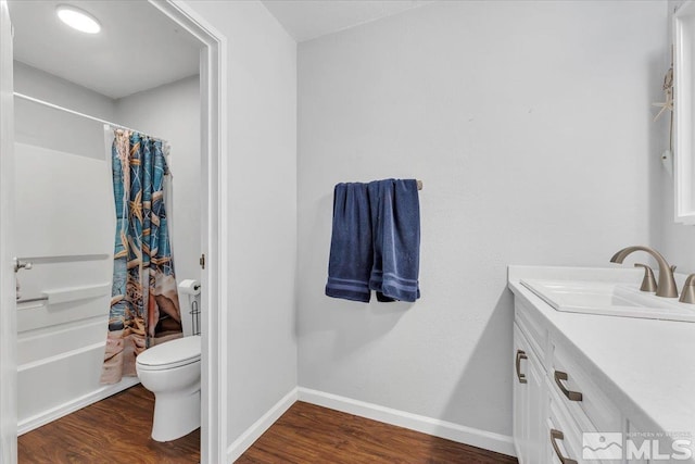 full bathroom featuring shower / bath combo, vanity, hardwood / wood-style flooring, and toilet