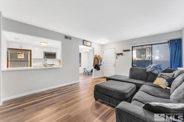 living room with light wood-type flooring and sink