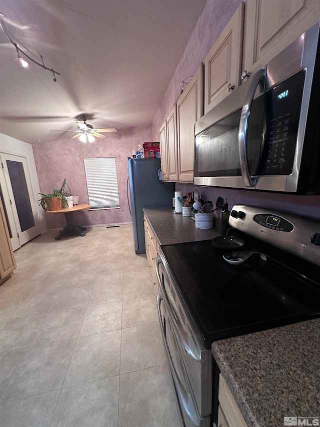 kitchen featuring light tile patterned flooring, ceiling fan, rail lighting, and stainless steel appliances