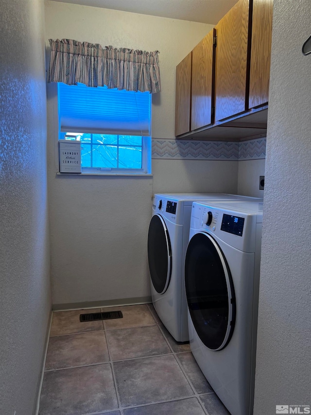 laundry room featuring separate washer and dryer and cabinets