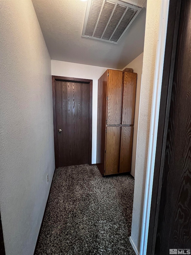 hallway featuring carpet floors and a textured ceiling