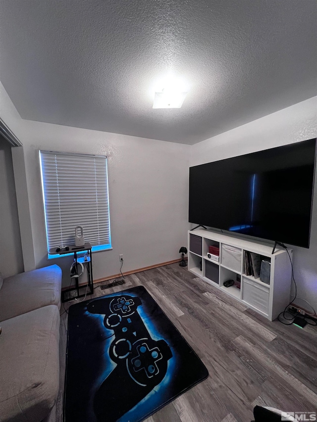 living room featuring hardwood / wood-style flooring and a textured ceiling