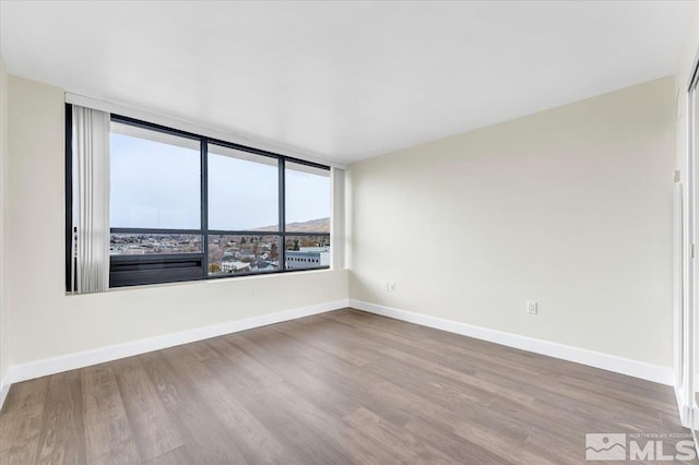 unfurnished room with hardwood / wood-style flooring