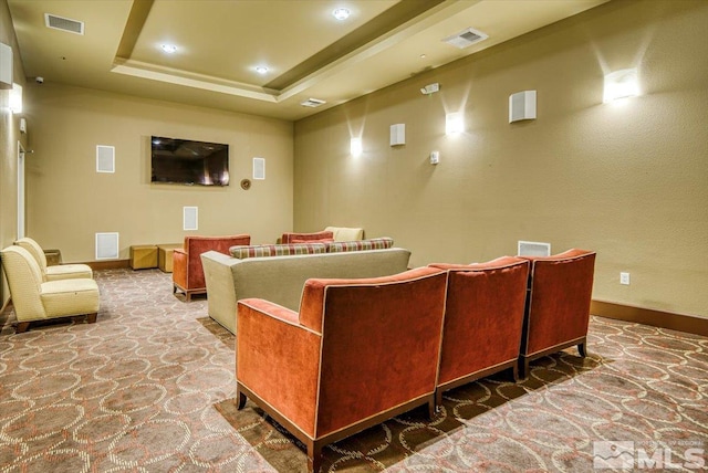 carpeted cinema room with a raised ceiling