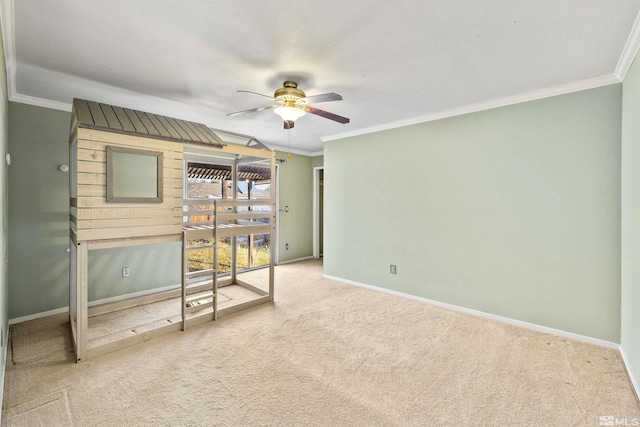 carpeted spare room with ceiling fan and ornamental molding