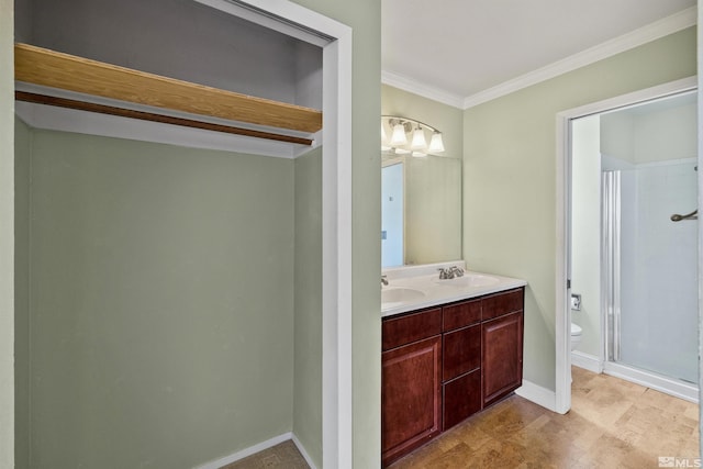 bathroom with vanity, toilet, a shower with shower door, and crown molding