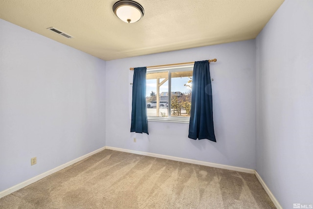 unfurnished room with carpet flooring and a textured ceiling