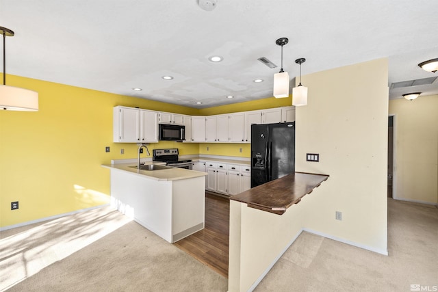 kitchen with kitchen peninsula, decorative light fixtures, white cabinetry, and black appliances