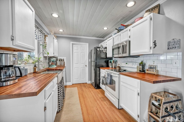 kitchen featuring butcher block counters, crown molding, white cabinets, and stainless steel appliances