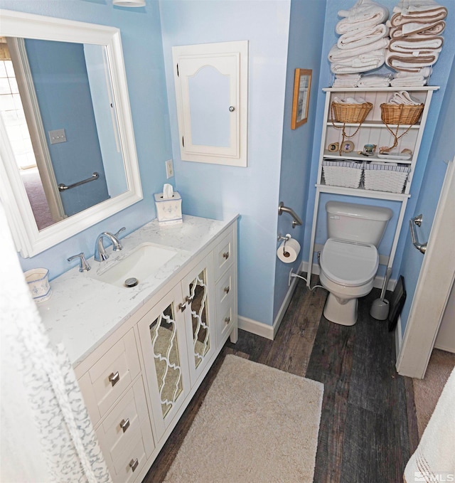 bathroom featuring vanity, hardwood / wood-style flooring, and toilet