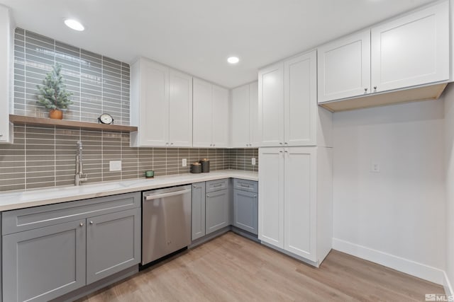 kitchen featuring stainless steel dishwasher, gray cabinetry, light wood-type flooring, and white cabinets