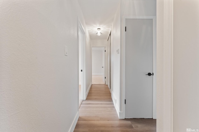 corridor with light hardwood / wood-style flooring