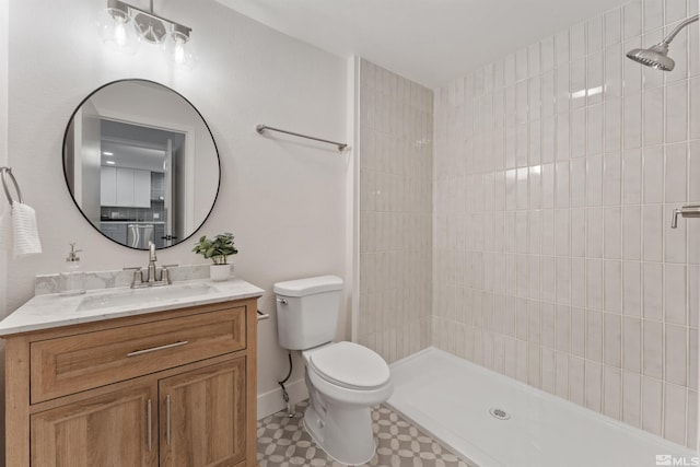 bathroom featuring vanity, toilet, and a tile shower