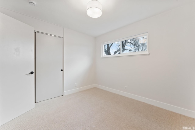 unfurnished bedroom featuring light carpet and a closet