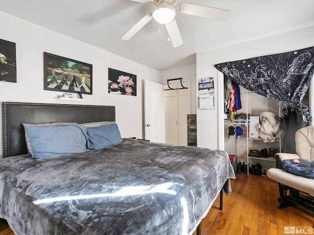 bedroom featuring hardwood / wood-style floors, ceiling fan, vaulted ceiling, and a closet