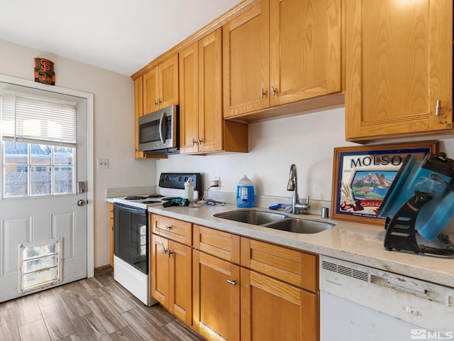 kitchen featuring white appliances, sink, and light hardwood / wood-style flooring