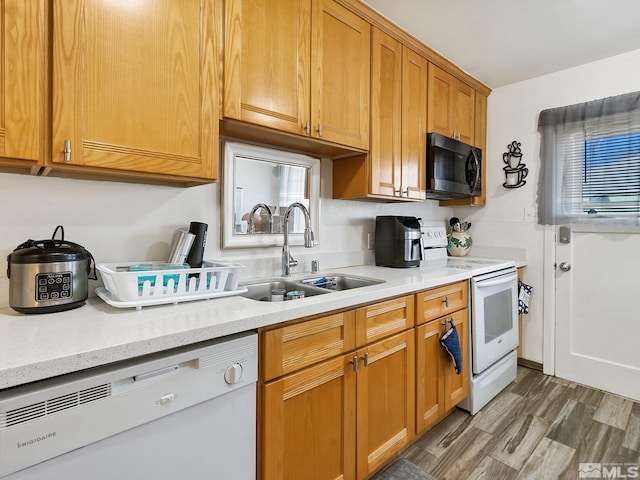 kitchen featuring light stone counters, sink, dark hardwood / wood-style floors, and white appliances