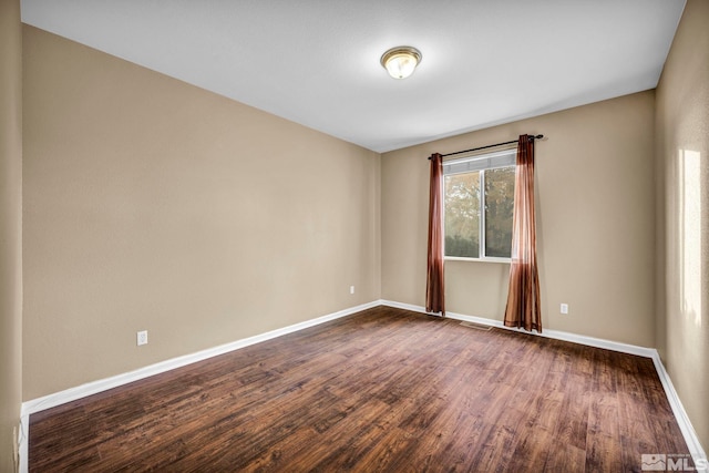 spare room with dark wood-type flooring