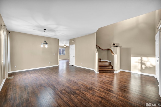 unfurnished living room featuring ceiling fan and dark wood-type flooring