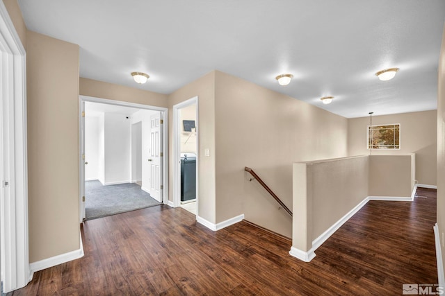 hall featuring washer / clothes dryer and dark wood-type flooring