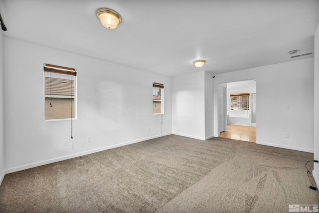 carpeted spare room featuring plenty of natural light