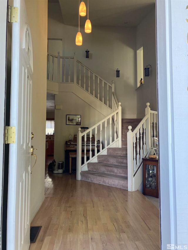 entryway featuring hardwood / wood-style floors and a towering ceiling