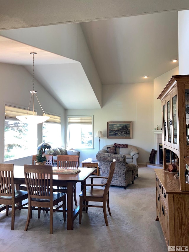 carpeted dining room with lofted ceiling