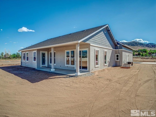 rear view of property with a patio area and a mountain view