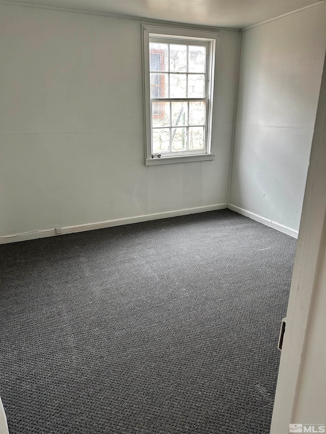 unfurnished room with dark carpet