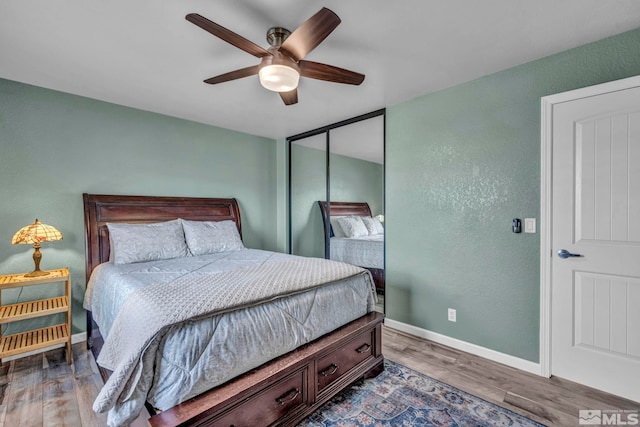 bedroom featuring wood-type flooring, a closet, and ceiling fan