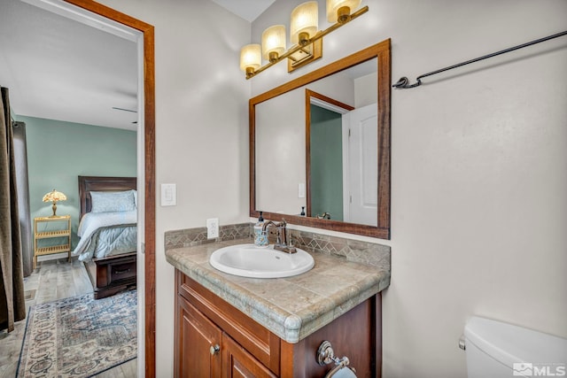 bathroom with toilet, vanity, and hardwood / wood-style flooring